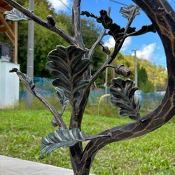 Detail eines Eichenzweigs am schmiedeeisernen Geländer beim Eingang zum Einfamilienhaus Detail eines Eichenzweigs am schmiedeeisernen Geländer beim Eingang zum Einfamilienhaus