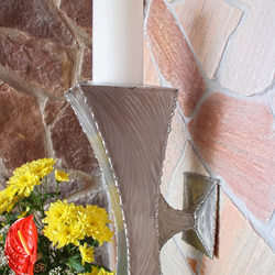 Handgefertigter Kerzenleuchter aus geschliffenem Edelstahl in einer Kapelle Handgefertigter Kerzenleuchter aus geschliffenem Edelstahl in einer Kapelle