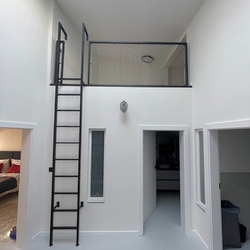 Modernes Metallgeländer mit Leiter, das die Nutzung von Räumen in hohen Zimmern ermöglicht Modernes Metallgeländer mit Leiter, das die Nutzung von Räumen in hohen Zimmern ermöglicht