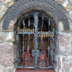 Schmiedeeisernes Heiligendenkmal – Inschrift, Gitter und Zeichen. St. Franz und St. Hyazintha – Fatima, St. Bernadette – Lourdes Schmiedeeisernes Heiligendenkmal – Inschrift, Gitter und Zeichen. St. Franz und St. Hyazintha – Fatima, St. Bernadette – Lourdes