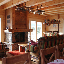 Gesamtansicht des Wohnzimmers einer Berghütte mit einer außergewöhnlichen, kunstvollen Beleuchtung von UKOVMI Gesamtansicht des Wohnzimmers einer Berghütte mit einer außergewöhnlichen, kunstvollen Beleuchtung von UKOVMI