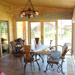 Geschlossene Laube einer Berghütte mit den luxuriösen geschmiedeten Möbel, Leuchte und Accessoires von UKOVMI Geschlossene Laube einer Berghütte mit den luxuriösen geschmiedeten Möbel, Leuchte und Accessoires von UKOVMI