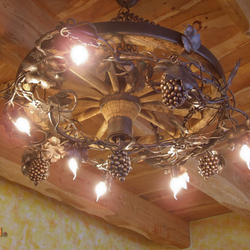 Einzigartiger Kronleuchter, von Hand geschmiedet als Weinrebe in ein Wagenrad – Innenleuchte in ländlichem Stil Einzigartiger Kronleuchter, von Hand geschmiedet als Weinrebe in ein Wagenrad – Innenleuchte in ländlichem Stil