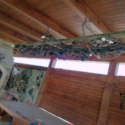 Gartenleuchte in einer Sommerlaube – geschmiedeter Kronleuchter Weinrebe auf der Holzleiter – künstlerische Vintage Leuchte Gartenleuchte in einer Sommerlaube – geschmiedeter Kronleuchter Weinrebe auf der Holzleiter – künstlerische Vintage Leuchte